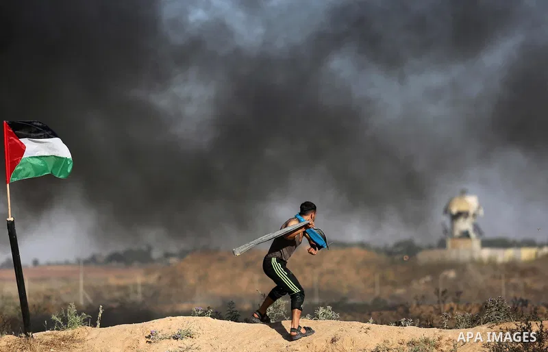 A Palestinian protester uses a slingshot to hurl stones towards Israeli security forces during clashes following a demonstration against the blockade on the Gaza Strip, near the border fence east of Jabalia refugee camp...