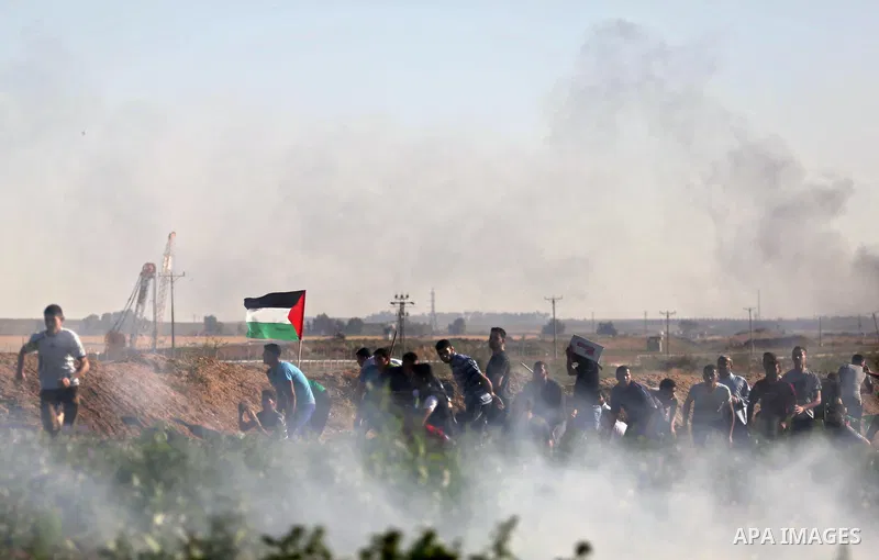Palestinian protesters take cover during clashes with Israeli security forces following a demonstration against the blockade on the Gaza Strip, near the border fence east of Jabalia refugee camp on June 5, 2017. Photo by...
