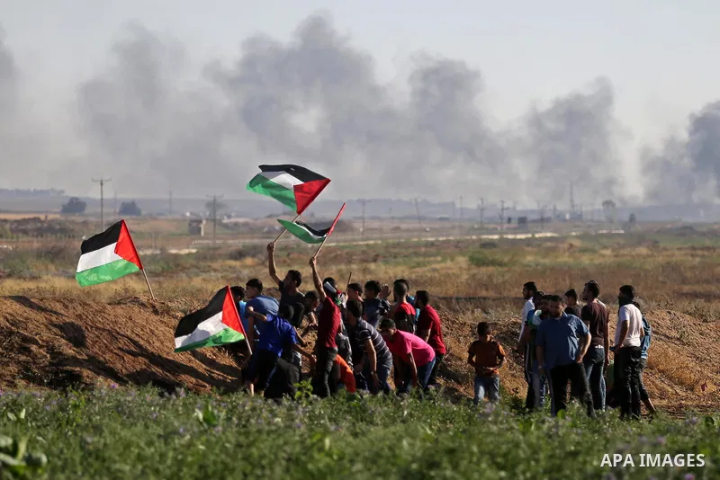 Palestinian protesters take cover during clashes with Israeli security forces following a demonstration against the blockade on the Gaza Strip, near the border fence east of Jabalia refugee camp on June 5, 2017. Photo by...