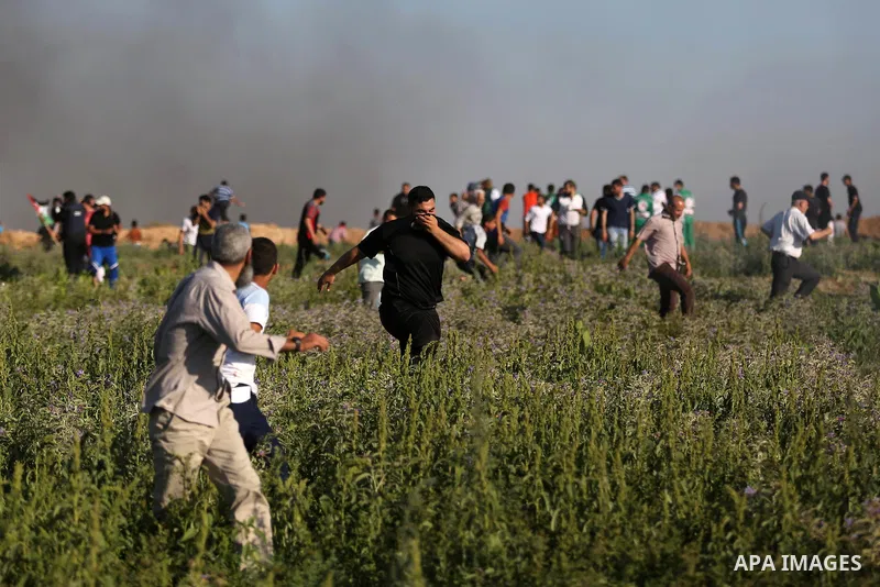 Palestinian protesters take cover during clashes with Israeli security forces following a demonstration against the blockade on the Gaza Strip, near the border fence east of Jabalia refugee camp on June 5, 2017. Photo by...
