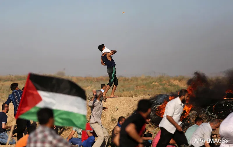 A Palestinian protester hurls stones towards Israeli security forces during clashes following a demonstration against the blockade on the Gaza Strip, near the border fence east of Jabalia refugee camp on June 5, 2017. Ph...
