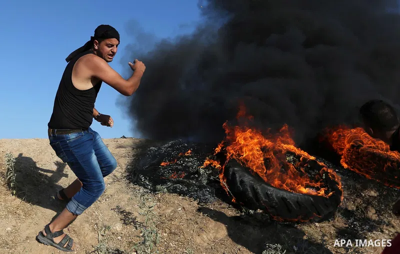 A Palestinian protester hurls stones towards Israeli security forces during clashes following a demonstration against the blockade on the Gaza Strip, near the border fence east of Jabalia refugee camp on June 5, 2017. Ph...