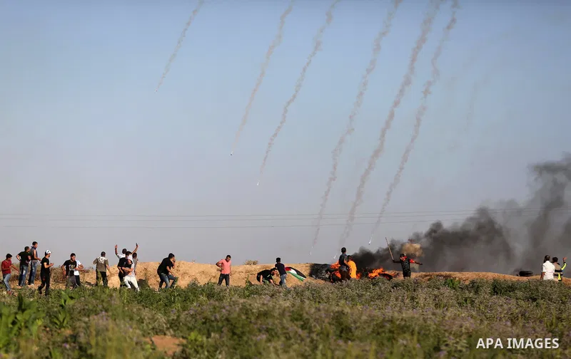 Palestinian protesters take cover during clashes with Israeli security forces following a demonstration against the blockade on the Gaza Strip, near the border fence east of Jabalia refugee camp on June 5, 2017. Photo by...