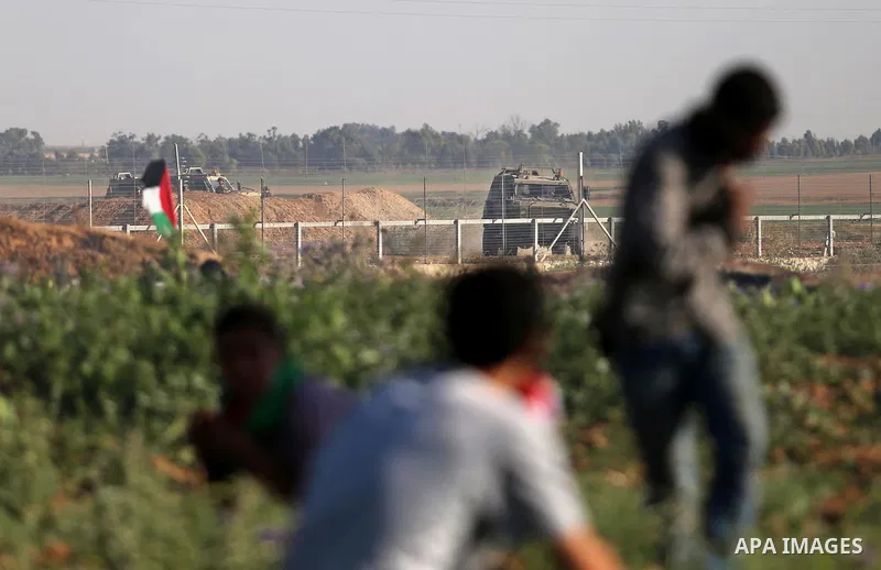 Palestinian protesters take cover during clashes with Israeli security forces following a demonstration against the blockade on the Gaza Strip, near the border fence east of Jabalia refugee camp on June 5, 2017. Photo by...