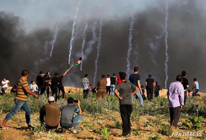 Palestinian protesters take cover during clashes with Israeli security forces following a demonstration against the blockade on the Gaza Strip, near the border fence east of Jabalia refugee camp on June 5, 2017. Photo by...