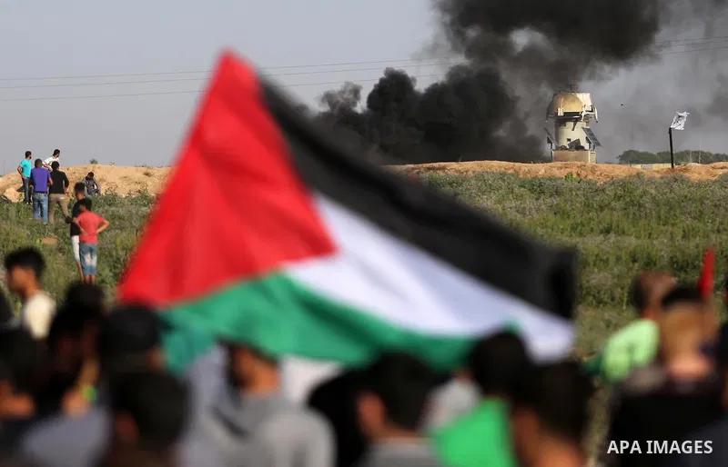 Palestinian protesters take cover during clashes with Israeli security forces following a demonstration against the blockade on the Gaza Strip, near the border fence east of Jabalia refugee camp on June 5, 2017. Photo by...