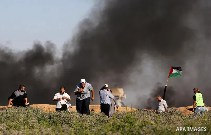 Palestinian protesters take cover during clashes with Israeli security forces following a demonstration against the blockade on the Gaza Strip, near the border fence east of Jabalia refugee camp on June 5, 2017. Photo by...