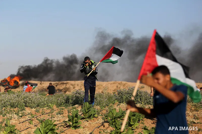 Palestinian protesters take cover during clashes with Israeli security forces following a demonstration against the blockade on the Gaza Strip, near the border fence east of Jabalia refugee camp on June 5, 2017. Photo by...
