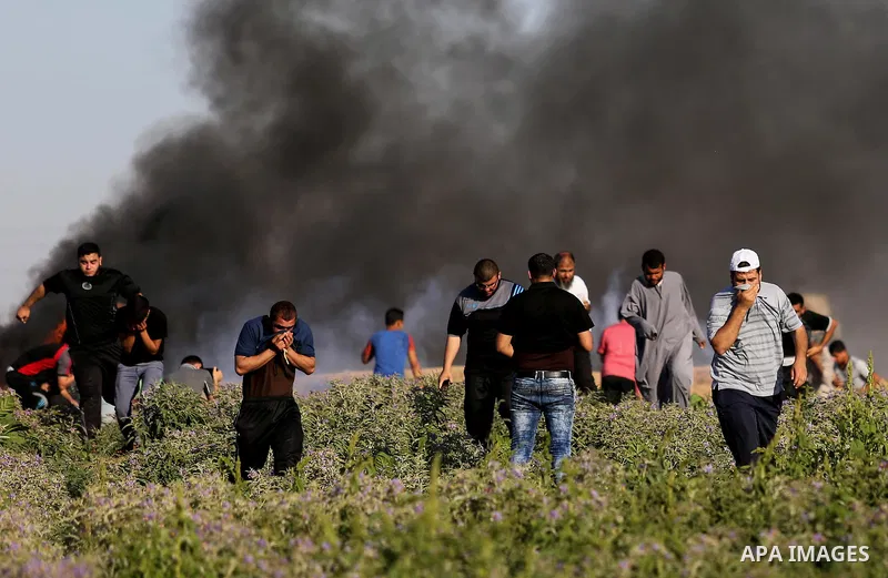 Palestinian protesters take cover during clashes with Israeli security forces following a demonstration against the blockade on the Gaza Strip, near the border fence east of Jabalia refugee camp on June 5, 2017. Photo by...