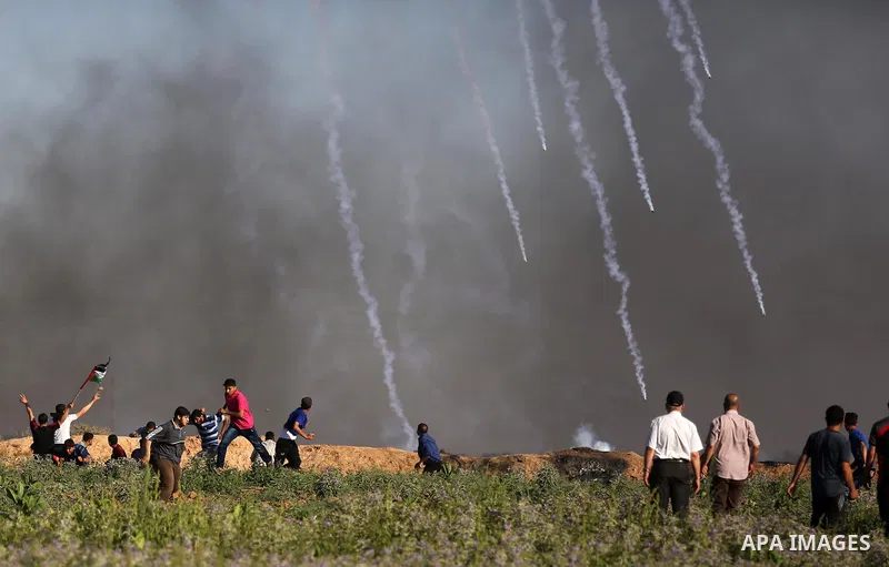 Palestinian protesters take cover during clashes with Israeli security forces following a demonstration against the blockade on the Gaza Strip, near the border fence east of Jabalia refugee camp on June 5, 2017. Photo by...