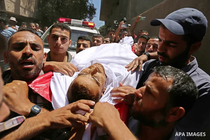 Mourners carry the body of a 25-year-old Palestinian Fadi al-Najjar who was killed by Israeli fire in the Gaza Strip during clashes with Israeli sceurity forces at the border fence the previous day, during his funeral in...