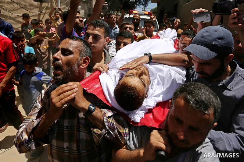 Mourners carry the body of a 25-year-old Palestinian Fadi al-Najjar who was killed by Israeli fire in the Gaza Strip during clashes with Israeli sceurity forces at the border fence the previous day, during his funeral in...