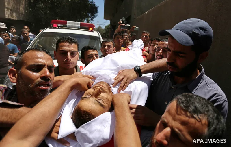 Mourners carry the body of a 25-year-old Palestinian Fadi al-Najjar who was killed by Israeli fire in the Gaza Strip during clashes with Israeli sceurity forces at the border fence the previous day, during his funeral in...