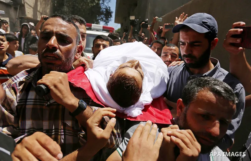 Mourners carry the body of a 25-year-old Palestinian Fadi al-Najjar who was killed by Israeli fire in the Gaza Strip during clashes with Israeli sceurity forces at the border fence the previous day, during his funeral in...