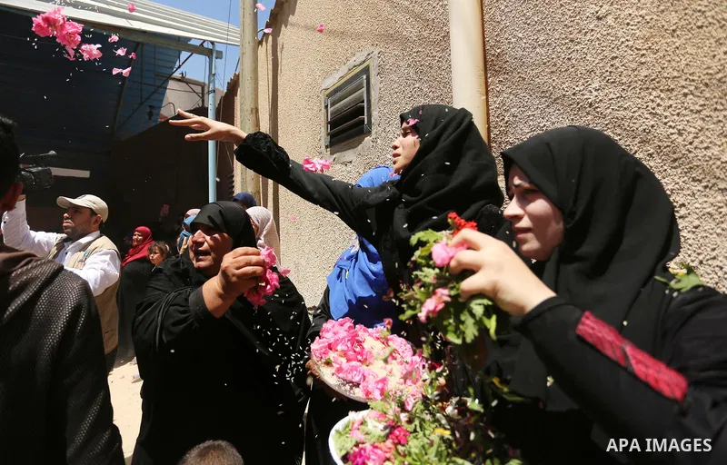 Mourners throw flowers at the body of a 25-year-old Palestinian Fadi al-Najjar who was killed by Israeli fire in the Gaza Strip during clashes with Israeli sceurity forces at the border fence the previous day, during his...