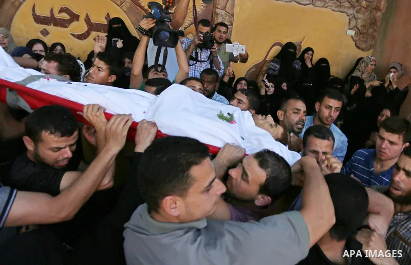 Mourners carry the body of a 25-year-old Palestinian Fadi al-Najjar who was killed by Israeli fire in the Gaza Strip during clashes with Israeli sceurity forces at the border fence the previous day, during his funeral in...