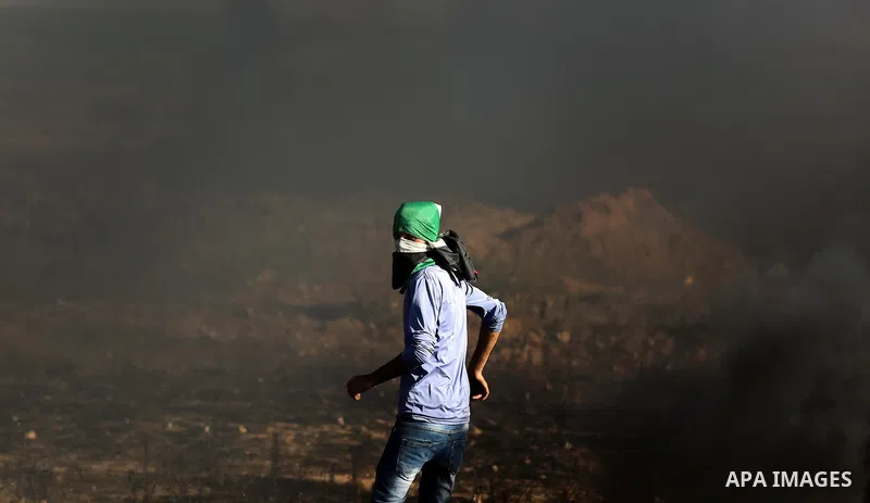 A Palestinian protester takes cover during clashes with Israeli security forces following a demonstration against the blockade on the Gaza Strip, near the border fence east of Jabalia refugee camp on June 7, 2017. Photo...