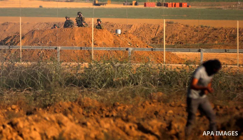 A Palestinian protester uses a slingshot to hurl stones towards Israeli security forces during clashes following a demonstration against the blockade on the Gaza Strip, near the border fence east of Jabalia refugee camp...