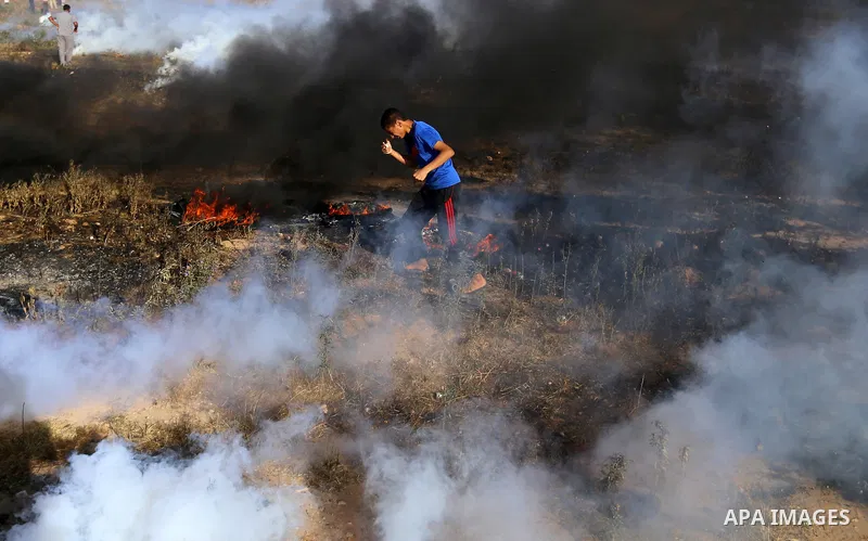 A Palestinian protester takes cover during clashes with Israeli security forces following a demonstration against the blockade on the Gaza Strip, near the border fence east of Jabalia refugee camp on June 7, 2017. Photo...