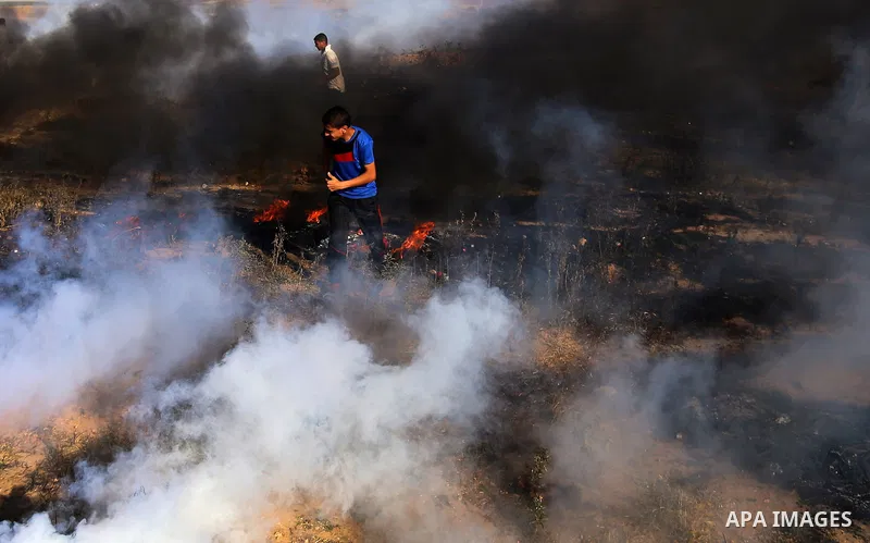 A Palestinian protester takes cover during clashes with Israeli security forces following a demonstration against the blockade on the Gaza Strip, near the border fence east of Jabalia refugee camp on June 7, 2017. Photo...