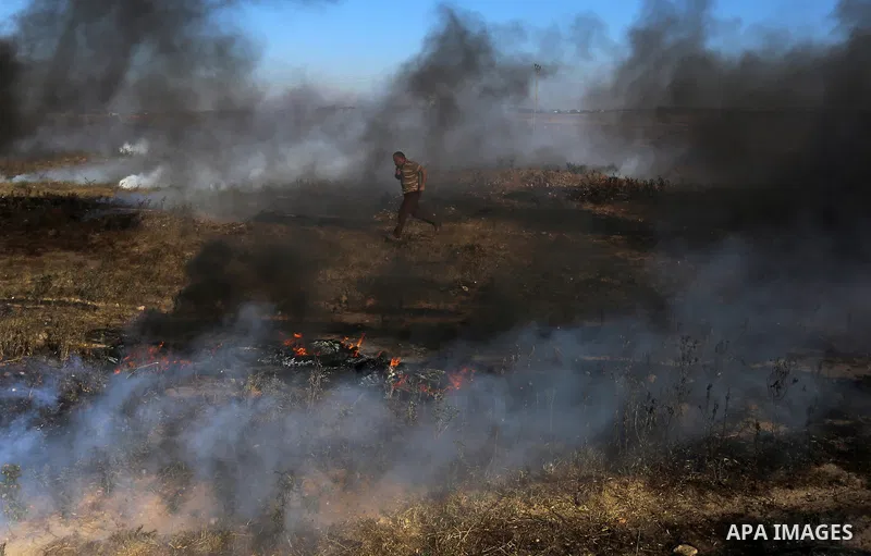 A Palestinian protester takes cover during clashes with Israeli security forces following a demonstration against the blockade on the Gaza Strip, near the border fence east of Jabalia refugee camp on June 7, 2017. Photo...