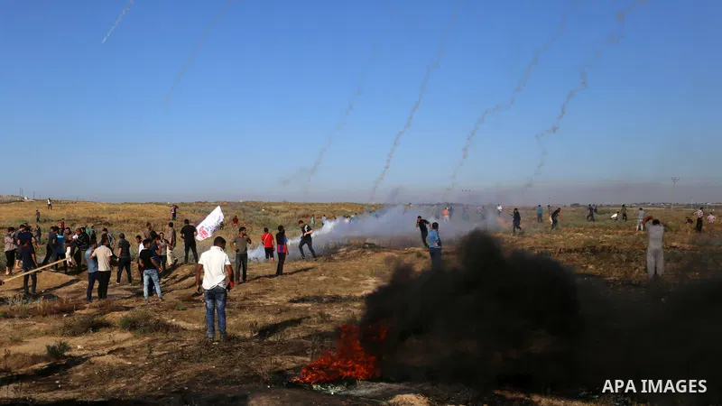 Palestinian protesters take cover during clashes with Israeli security forces following a demonstration against the blockade on the Gaza Strip, near the border fence east of Jabalia refugee camp on June 7, 2017. Photo by...