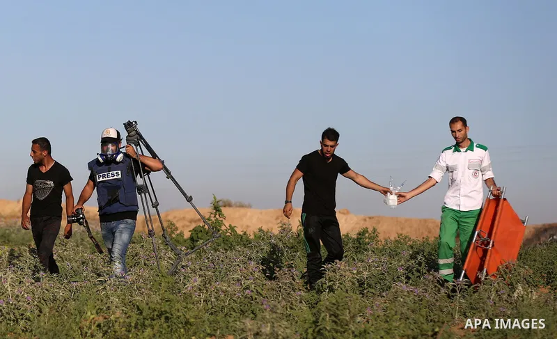 Palestinian protesters take cover during clashes with Israeli security forces following a demonstration against the blockade on the Gaza Strip, near the border fence east of Jabalia refugee camp on June 7, 2017. Photo by...