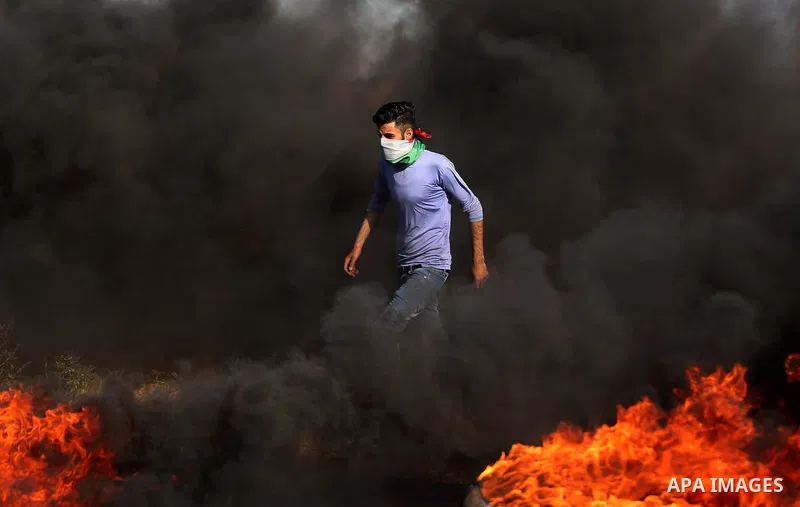 A Palestinian protester takes cover during clashes with Israeli security forces following a demonstration against the blockade on the Gaza Strip, near the border fence east of Jabalia refugee camp on June 7, 2017. Photo...