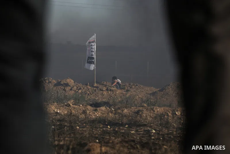 Palestinian protesters take cover during clashes with Israeli security forces following a demonstration against the blockade on the Gaza Strip, near the border fence east of Jabalia refugee camp on June 7, 2017. Photo by...