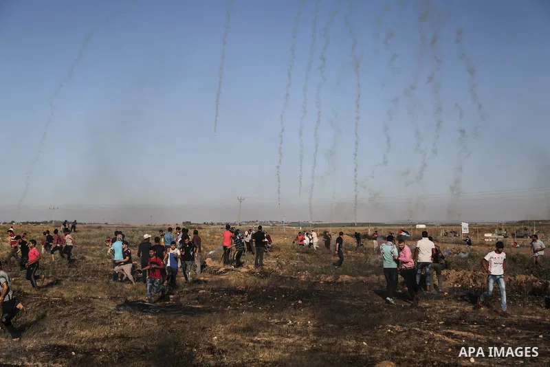 Palestinian protesters take cover during clashes with Israeli security forces following a demonstration against the blockade on the Gaza Strip, near the border fence east of Jabalia refugee camp on June 7, 2017. Photo by...