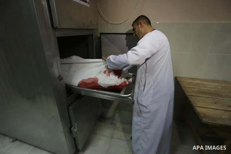 A relative mourns over the body of Palestinian Aaed Goma at a hospital morgue in the northern Gaza Strip June 9, 2017. Photo by Mohammed Asad