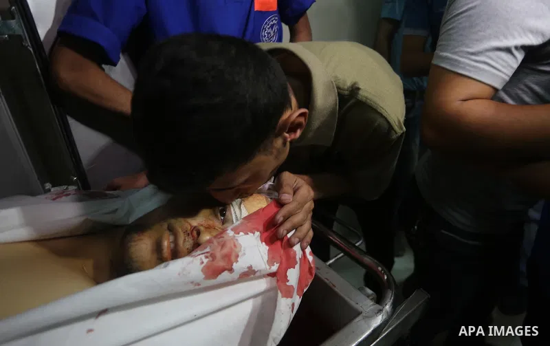 A relative mourns over the body of Palestinian Aaed Goma at a hospital morgue in the northern Gaza Strip June 9, 2017. Photo by Mohammed Asad