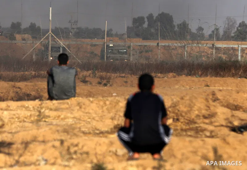 Palestinian protesters take cover during clashes with Israeli security forces following a demonstration against the blockade on the Gaza Strip, near the border fence east of Jabalia refugee camp on June 9, 2017. Photo by...