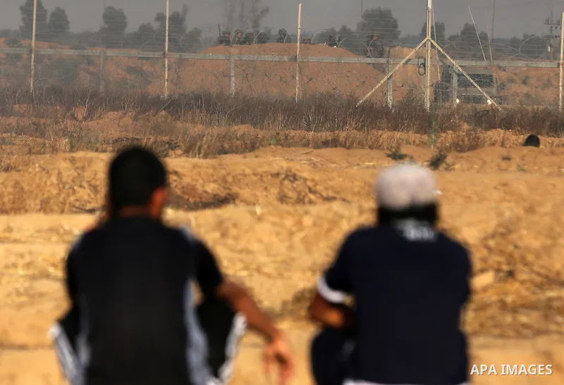 Palestinian protesters take cover during clashes with Israeli security forces following a demonstration against the blockade on the Gaza Strip, near the border fence east of Jabalia refugee camp on June 9, 2017. Photo by...