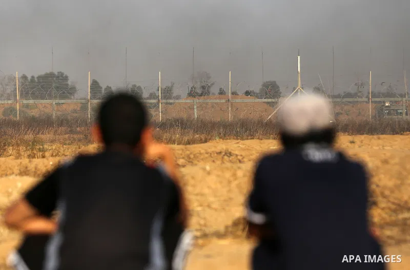 Palestinian protesters take cover during clashes with Israeli security forces following a demonstration against the blockade on the Gaza Strip, near the border fence east of Jabalia refugee camp on June 9, 2017. Photo by...