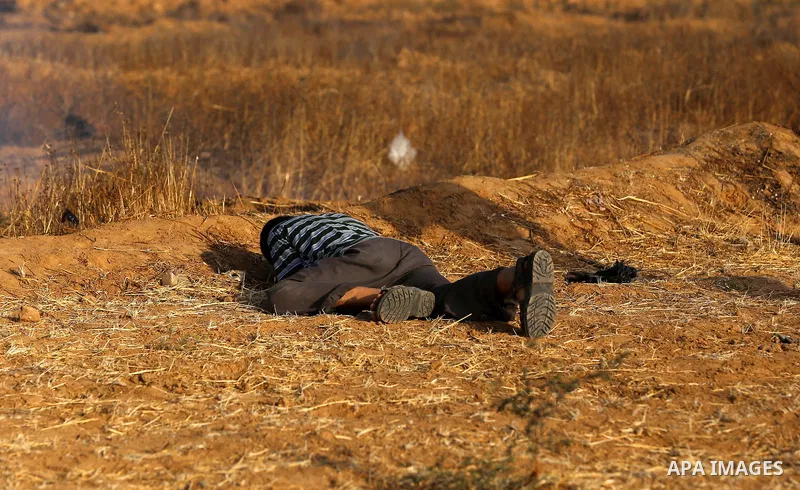 Palestinian protesters take cover during clashes with Israeli security forces following a demonstration against the blockade on the Gaza Strip, near the border fence east of Jabalia refugee camp on June 9, 2017. Photo by...