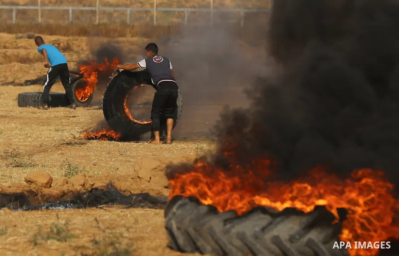 A Palestinian protester burns tires during clashes with Israeli security forces following a demonstration against the blockade on the Gaza Strip, near the border fence east of Jabalia refugee camp on June 9, 2017. Photo...