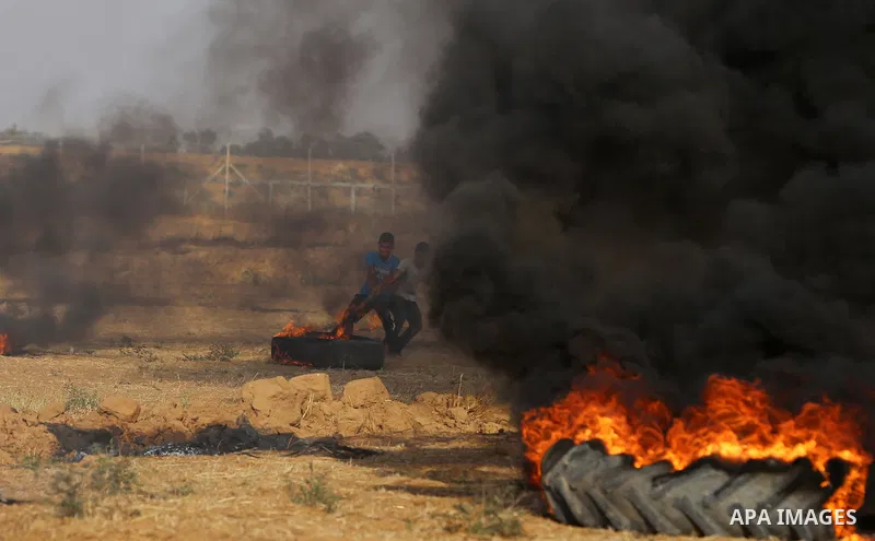 A Palestinian protester burns tires during clashes with Israeli security forces following a demonstration against the blockade on the Gaza Strip, near the border fence east of Jabalia refugee camp on June 9, 2017. Photo...