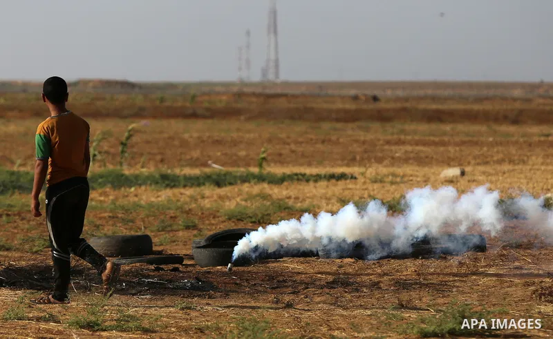 Palestinian protesters take cover during clashes with Israeli security forces following a demonstration against the blockade on the Gaza Strip, near the border fence east of Jabalia refugee camp on June 9, 2017. Photo by...