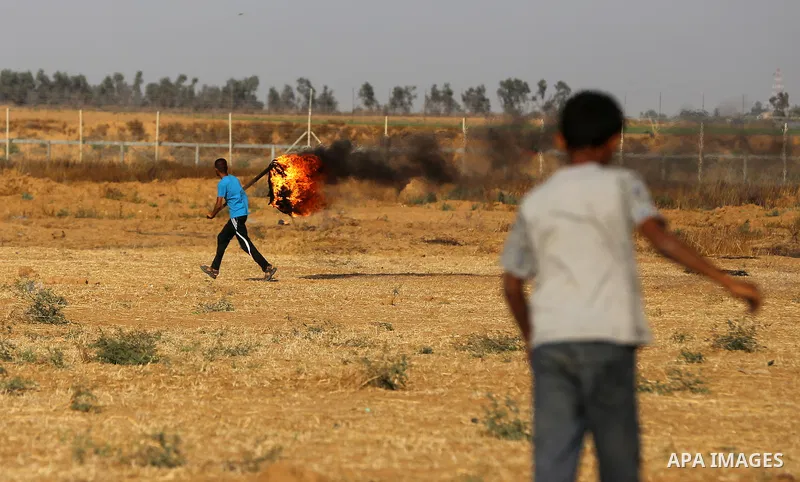 A Palestinian protester burns tires during clashes with Israeli security forces following a demonstration against the blockade on the Gaza Strip, near the border fence east of Jabalia refugee camp on June 9, 2017. Photo...