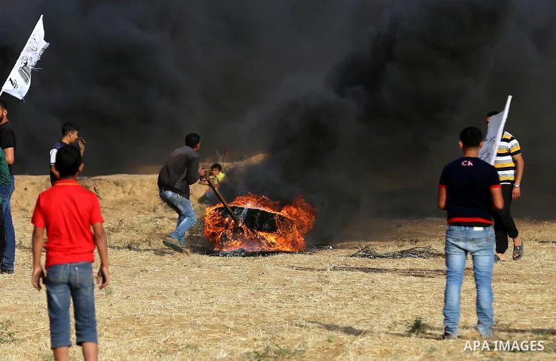 A Palestinian protester burns tires during clashes with Israeli security forces following a demonstration against the blockade on the Gaza Strip, near the border fence east of Jabalia refugee camp on June 9, 2017. Photo...