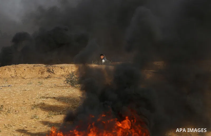 A Palestinian protester burns tires during clashes with Israeli security forces following a demonstration against the blockade on the Gaza Strip, near the border fence east of Jabalia refugee camp on June 9, 2017. Photo...