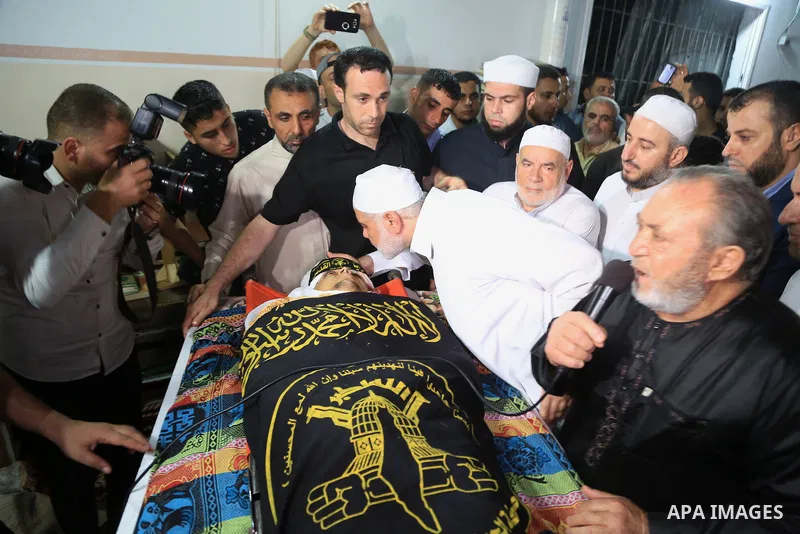 Ismail Haniyeh, leader of Hamas, kisses the head of Aaed Goma, 35, who was killed by Israeli gunfire during clashes, in Jabalia refugee camp in the northern Gaza strip on June 09, 2017. Photo by Dawod Abo Elkass