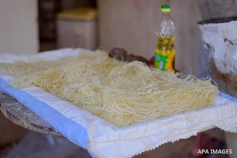 An Egyptian vendor prepares a traditional sweets known as "Konafa" on the Muslim holy fasting month of Ramadan at market in Cairo, Egypt, on June 10, 2017. Ramadan is sacred to Muslims because it is during that month tha...