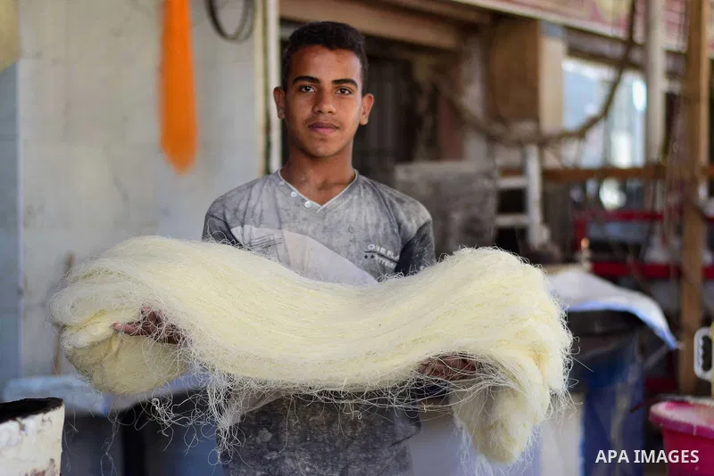 An Egyptian vendor prepares a traditional sweets known as "Konafa" on the Muslim holy fasting month of Ramadan at market in Cairo, Egypt, on June 10, 2017. Ramadan is sacred to Muslims because it is during that month tha...