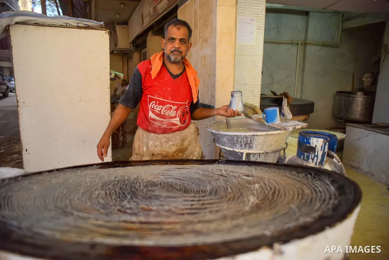An Egyptian vendor prepares a traditional sweets known as "Konafa" on the Muslim holy fasting month of Ramadan at market in Cairo, Egypt, on June 10, 2017. Ramadan is sacred to Muslims because it is during that month tha...