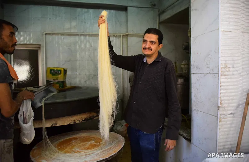 An Egyptian vendor prepares a traditional sweets known as "Konafa" on the Muslim holy fasting month of Ramadan at market in Cairo, Egypt, on June 10, 2017. Ramadan is sacred to Muslims because it is during that month tha...