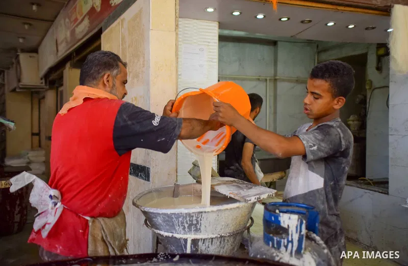 An Egyptian vendor prepares a traditional sweets known as "Konafa" on the Muslim holy fasting month of Ramadan at market in Cairo, Egypt, on June 10, 2017. Ramadan is sacred to Muslims because it is during that month tha...