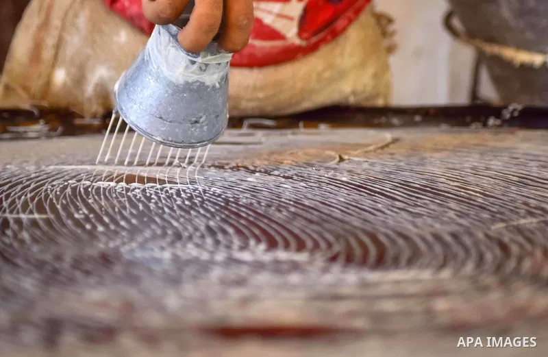 An Egyptian vendor prepares a traditional sweets known as "Konafa" on the Muslim holy fasting month of Ramadan at market in Cairo, Egypt, on June 10, 2017. Ramadan is sacred to Muslims because it is during that month tha...
