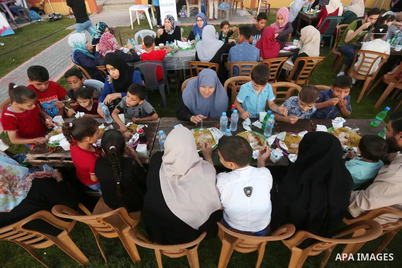 A picture taken on June 11, 2017 shows Palestinian Muslims eat their Iftar meal as they break their fast during the holy fasting month of Ramadan, at a park in Gaza city. Ramadan is sacred to Muslims because it is during...